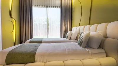 two beds in a room with a large window at Villa Delina heated pool not overlooked in Marrakech