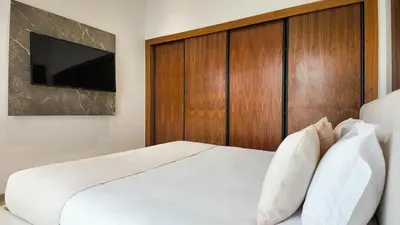 a bedroom with a white bed with a wooden headboard at Villa Clea heated pool not overlooked in Marrakech