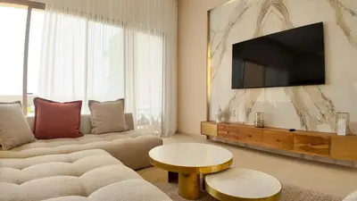 a living room with a couch and a flat screen tv at Villa Clea heated pool not overlooked in Marrakech