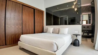 a bedroom with a large white bed and a mirror at Villa Clea heated pool not overlooked in Marrakech