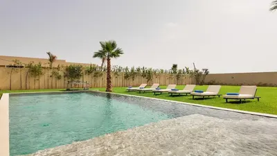 a swimming pool with lounge chairs and a palm tree at Villa Clea heated pool not overlooked in Marrakech