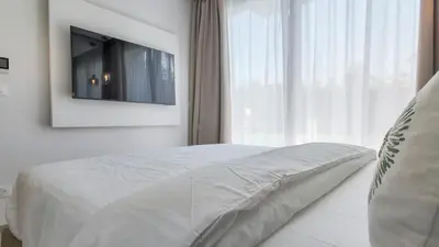 a bedroom with a bed with a television on the wall at Wintering Bungalow-Heated pool not overlooked in Marrakech
