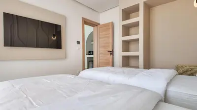 two white beds in a room with a flat screen tv at Wintering Bungalow-Heated pool not overlooked in Marrakech