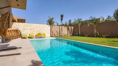 a swimming pool with blue water in a yard at Wintering Bungalow-Heated pool not overlooked in Marrakech