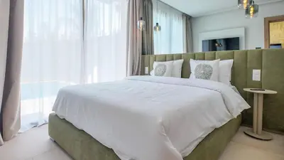 a bedroom with a large white bed and a window at Wintering Bungalow-Heated pool not overlooked in Marrakech