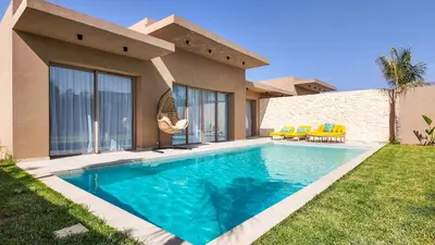 a swimming pool in front of a house at Wintering Bungalow-Heated pool not overlooked in Marrakech