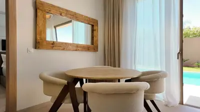 a table and chairs in a room with a mirror at Majorelle Bungalow - Heated pool, not overlooked in Marrakech