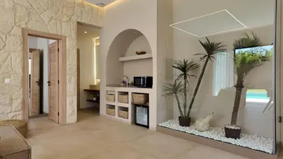 a living room with two palm trees and a fireplace at Majorelle Bungalow - Heated pool, not overlooked in Marrakech