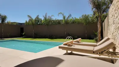 a swimming pool with a lounge chair next to a fence at Majorelle Bungalow - Heated pool, not overlooked in Marrakech