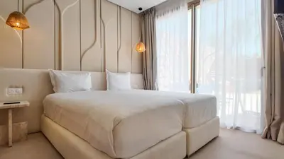 a bedroom with a large white bed and a large window at Targa Bungalow - Heated pool, not overlooked in Marrakech