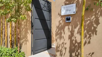 a black door with a sign on the side of a building at Targa Bungalow - Heated pool, not overlooked in Marrakech