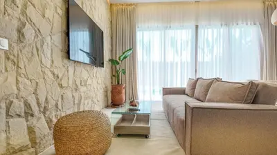 a living room with a couch and a stone wall at Targa Bungalow - Heated pool, not overlooked in Marrakech
