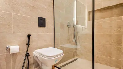 a bathroom with a toilet and a glass shower at Medina Bungalow - Heated Pool, not overlooked in Marrakech