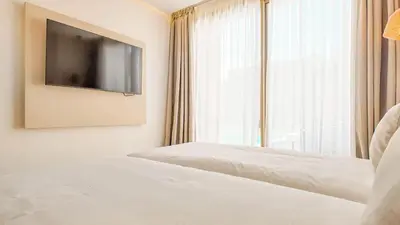 a bedroom with a bed with a tv and a window at Medina Bungalow - Heated Pool, not overlooked in Marrakech