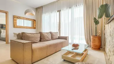 a living room with a couch and a glass table at Medina Bungalow - Heated Pool, not overlooked in Marrakech