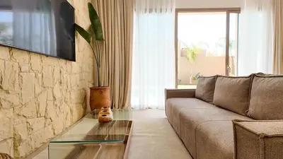 a living room with a couch and a glass coffee table at Agdal Bungalow - Heated swimming pool, not overlooked in Marrakech