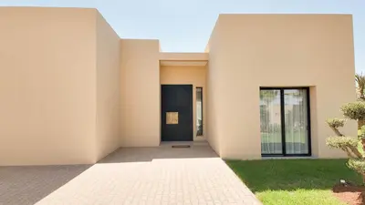 a white house with a door and a yard at Villa Maryam heated pool not overlooked in Marrakech