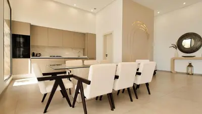 a dining room with a table and white chairs at Villa Maryam heated pool not overlooked in Marrakech