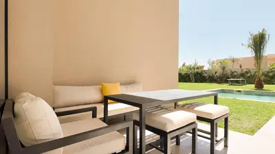 a patio with a table and chairs and a couch at Villa Maryam heated pool not overlooked in Marrakech