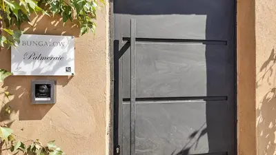 a door with a sign on the side of a building at Palm Grove Bungalow - Heated pool, not overlooked in Marrakech