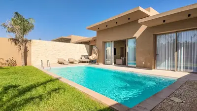 a swimming pool in front of a house at Palm Grove Bungalow - Heated pool, not overlooked in Marrakech