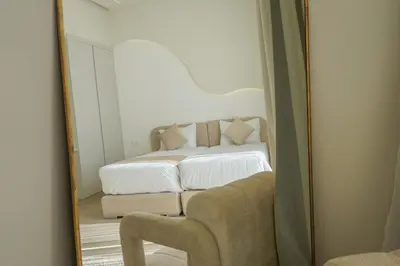 a mirror reflecting a bedroom with a bed and a couch at Villa Jibal heated pool not overlooked in Marrakech