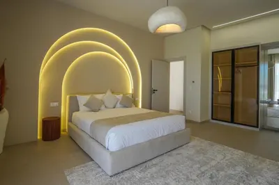 a bedroom with a large bed with an arch overhead at Villa Jibal heated pool not overlooked in Marrakech