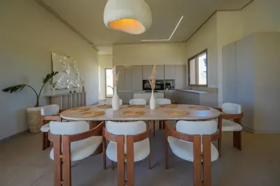 a dining room with a wooden table and white chairs at Villa Jibal heated pool not overlooked in Marrakech