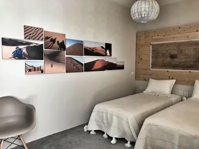 a bedroom with two beds and pictures on the wall at Riad Yara Farah in Marrakech
