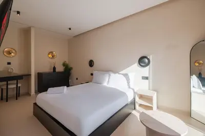 a bedroom with a large white bed and a desk at Havre de paix moderne pour voyageurs exigeants in Marrakech