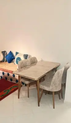 a table and a couch with a table and chairs at Appartement 2 Chambres Marrakech Targa Parking WiFi in Marrakech