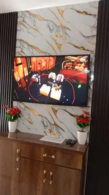 a flat screen tv sitting on top of a cabinet at Appartement 2 Chambres Marrakech Targa Parking WiFi in Marrakech