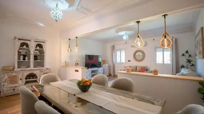 a living room with a dining table and a kitchen at Appt Duplex dans village touristique, sublime vue, proche médina in Marrakech