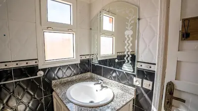 a bathroom with a sink and a mirror at Appt Duplex dans village touristique, sublime vue, proche médina in Marrakech