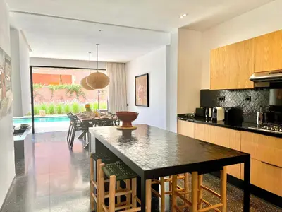 a kitchen and dining room with a table and chairs at Villa Bohō - 4 suites in El Rhechat