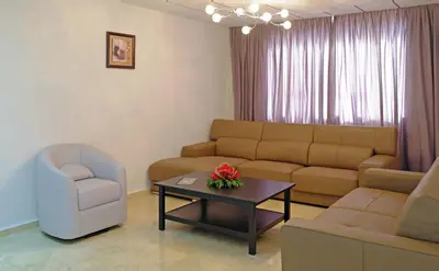 a living room with a couch and a table and a chair at Appart Hôtel Mouna in Marrakech