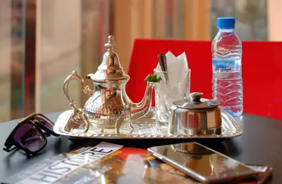 a tray with a tea kettle and a bottle of water at Appart Hôtel Mouna in Marrakech