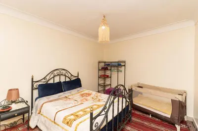 a bedroom with a bed and a table and a lamp at Dar Si Ahmed in Marrakech