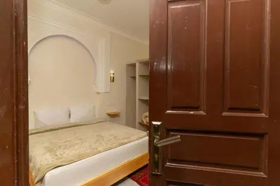 a small bedroom with a bed and an open door at Dar Si Ahmed in Marrakech