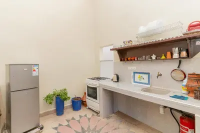 a kitchen with a stove and a sink and a refrigerator at Dar Si Ahmed in Marrakech