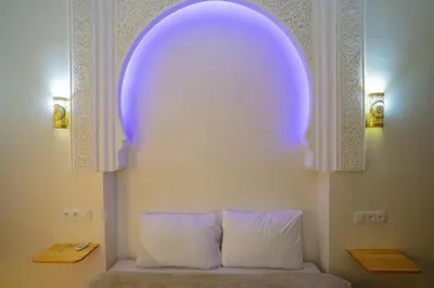 a room with an arch with a bed and two pillows at Dar Si Ahmed in Marrakech