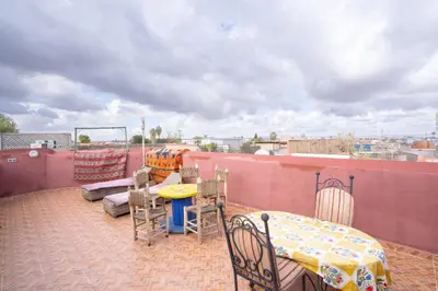 a patio with a table and chairs on a roof at Dar Si Ahmed in Marrakech