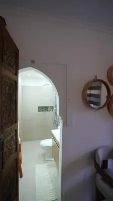 a bathroom with a toilet and a sink and a mirror at Riad Oumhani in Marrakech