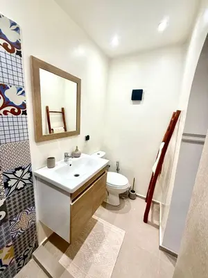 a bathroom with a sink and a toilet and a mirror at Riad Oumhani in Marrakech