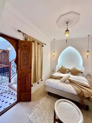 a bedroom with a bed with a blue headboard at Riad Oumhani in Marrakech