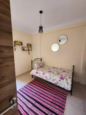 a bedroom with a bed and a colorful rug at Aéroport appartement Marrakech in Marrakech