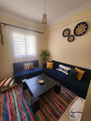 a living room with a blue couch and a coffee table at Aéroport appartement Marrakech in Marrakech