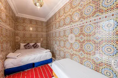 a bedroom with a bed in a room with wallpaper at Dar N3 in Marrakech