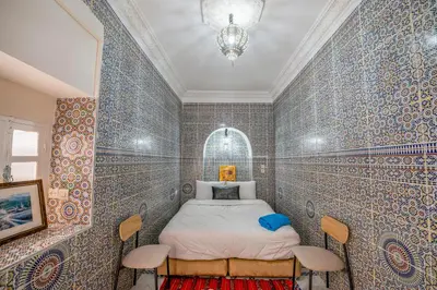 a bedroom with a bed in a room with blue tiled walls at Dar N3 in Marrakech