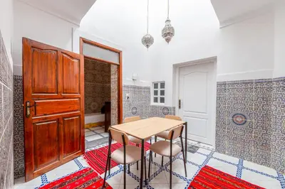a dining room with a wooden table and chairs at Dar N3 in Marrakech